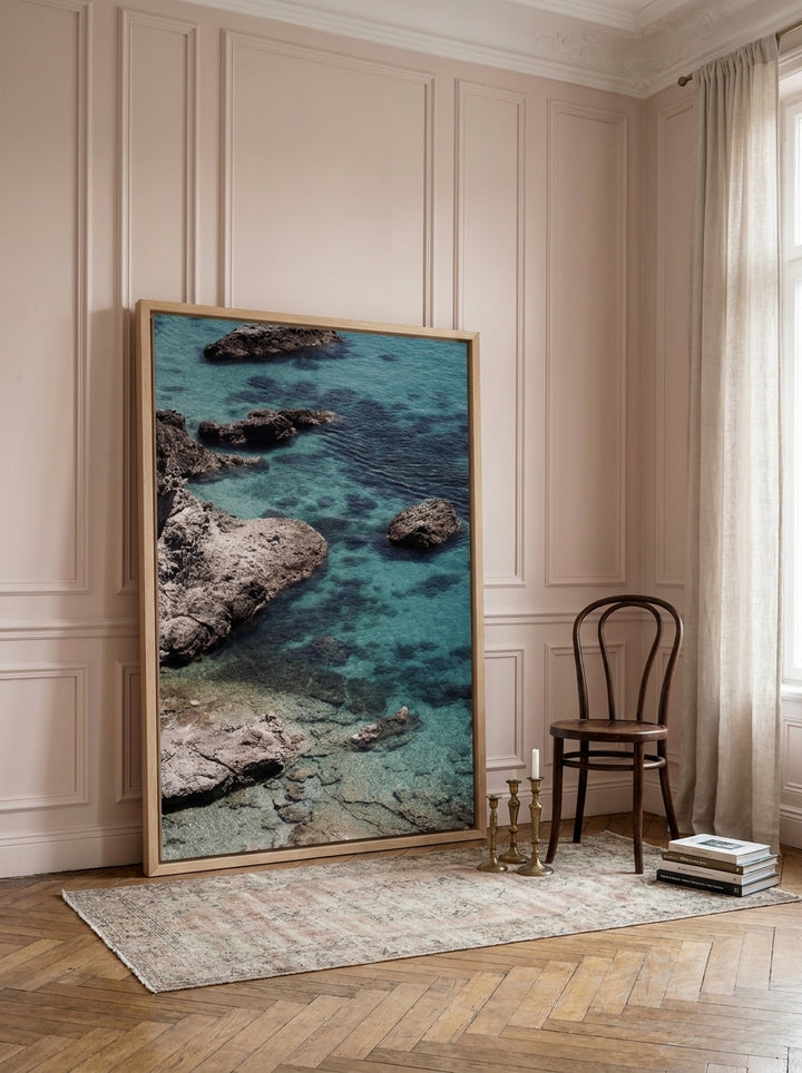 Oversized statement canvas wall art with a natural timber surround leaning against the wall in a Parisian bedroom