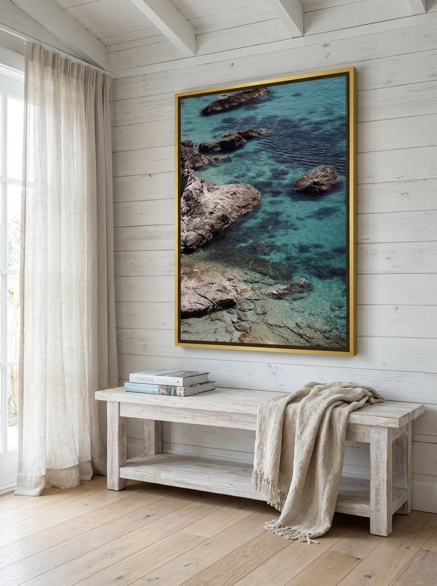 Oversized statement canvas wall art with a gold leaf surround styled on the wall in a coastal living room