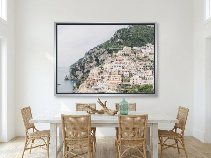 Oversized statement canvas wall art with a silver leaf surround styled on the wall in a coastal dining room