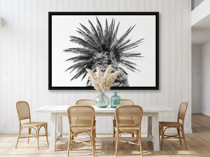 Oversized statement canvas wall art with a black surround styled on the wall in a coastal dining room