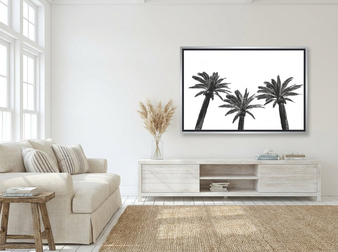 Oversized statement canvas wall art with a silver leaf surround styled on the wall in a coastal living room