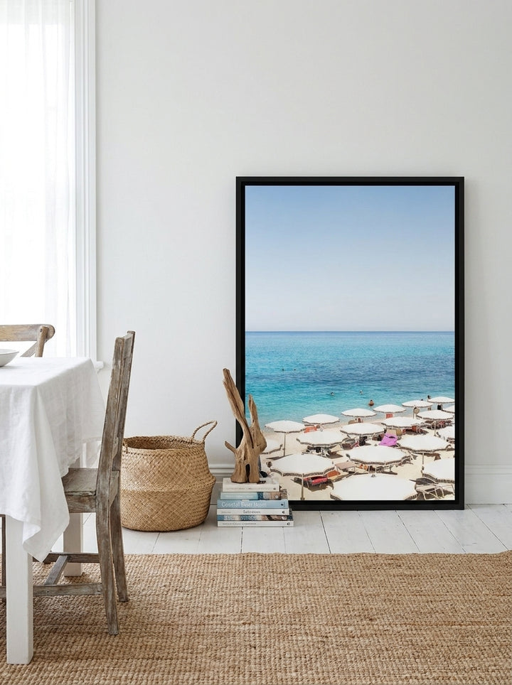 Canvas wall art with a black surround leaning against the wall in a coastal dining room