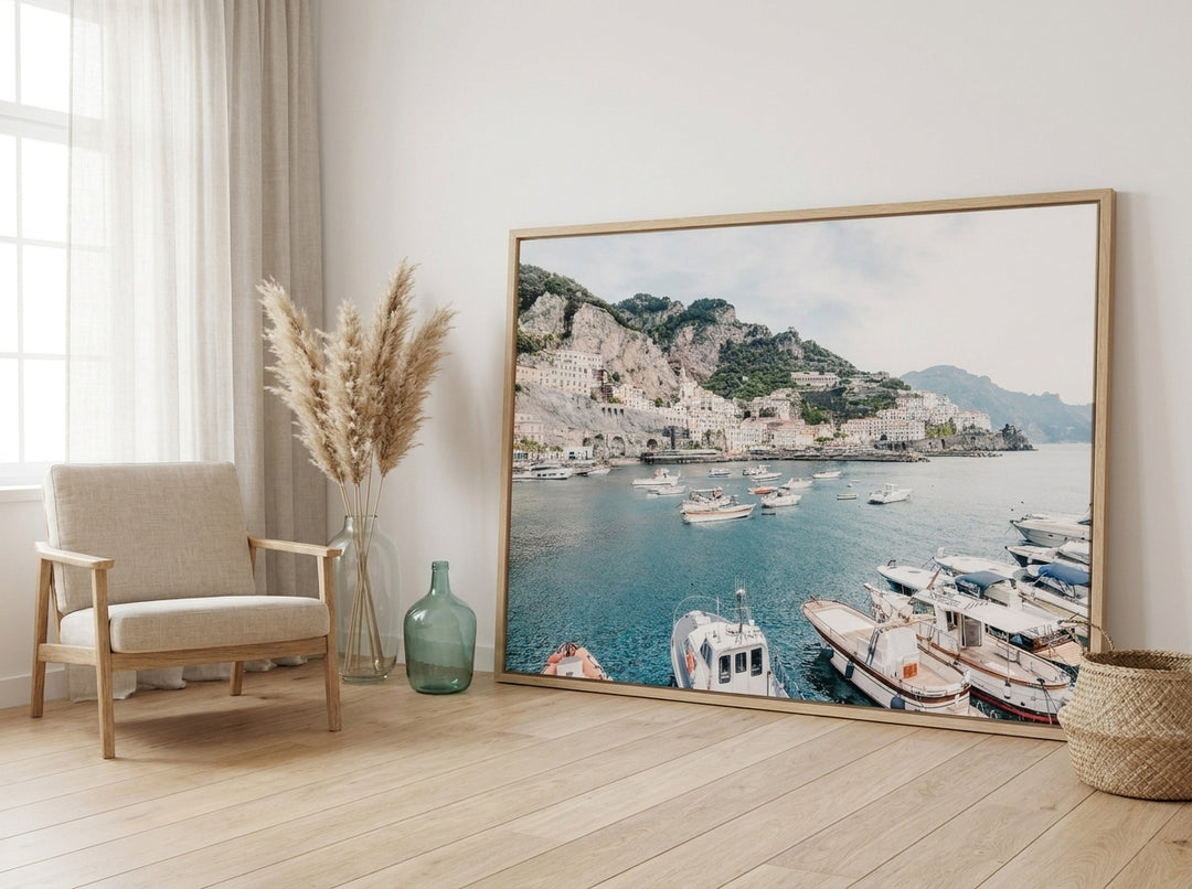 Oversized statement canvas wall art with a natural timber surround leaning against the wall in a coastal dining room
