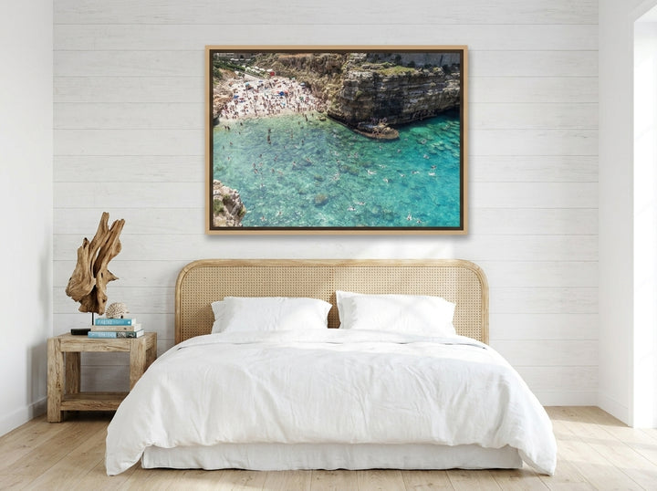 Oversized statement canvas wall art with a natural timber surround styled on the wall in a coastal bedroom