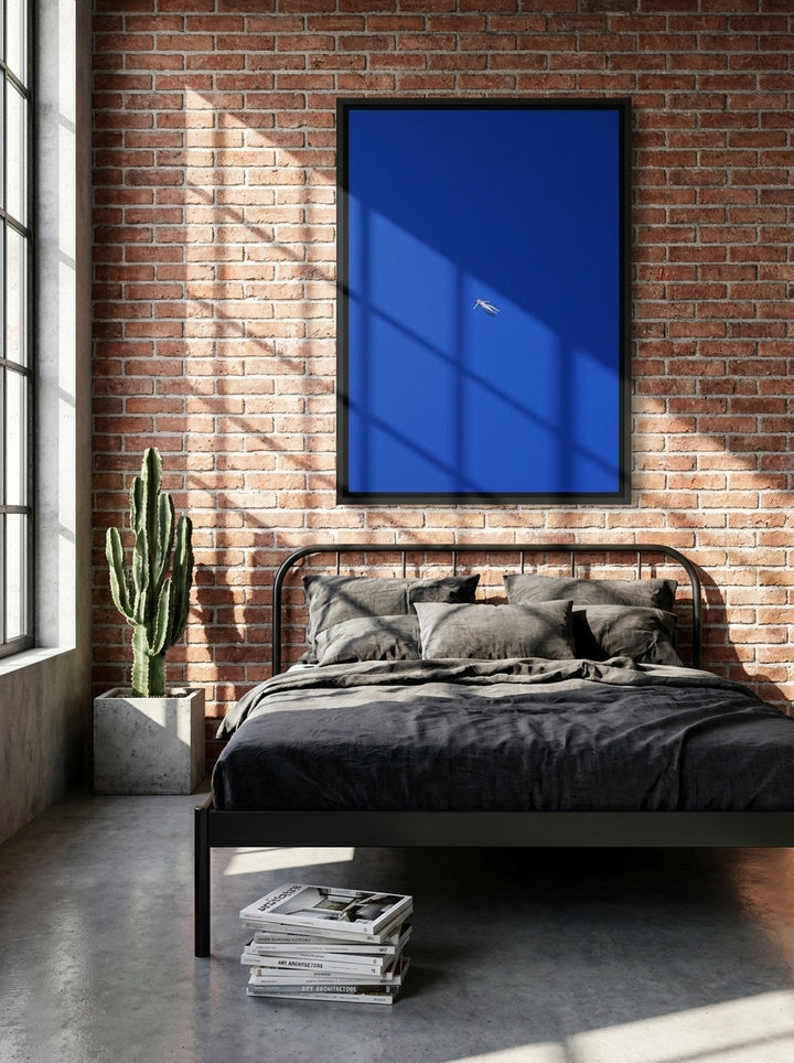 Canvas wall art with a black surround styled on the wall in an industrial loft bedroom