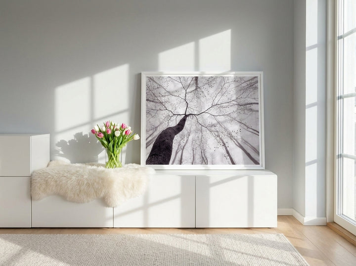 Modern wall art print standing on a sideboard in a bright Scandinavian bedroom