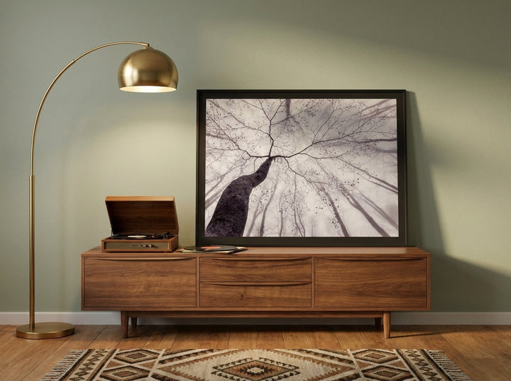 Modern wall art print standing on a sideboard in a mid-century living room