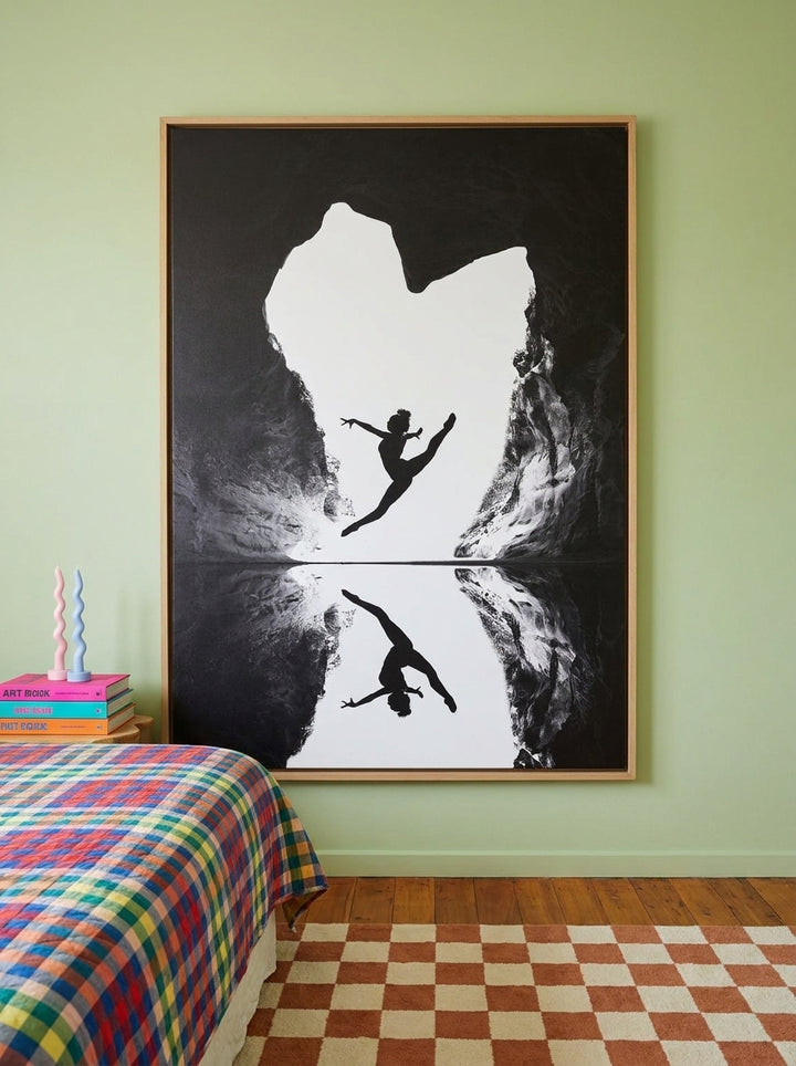 Canvas wall art with a natural timber surround styled on the wall in a colourful eclectic bedroom