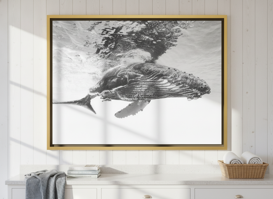 Oversized statement canvas wall art with a gold leaf surround styled on the wall in a coastal bathroom