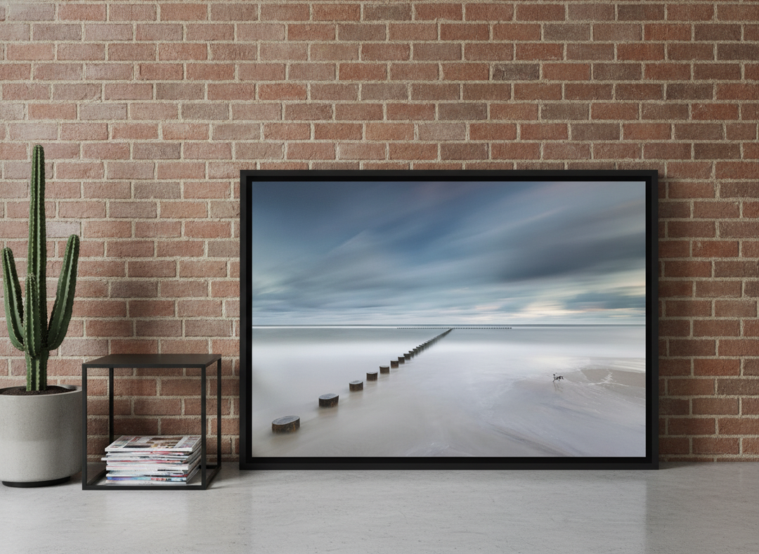 Canvas wall art with a black surround leaning against the wall in an industrial loft bedroom