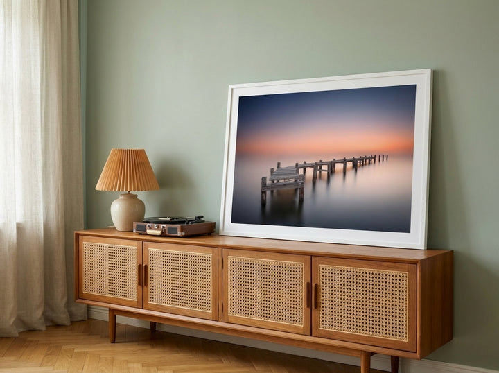 Modern wall art print standing on a sideboard in a mid-century bedroom