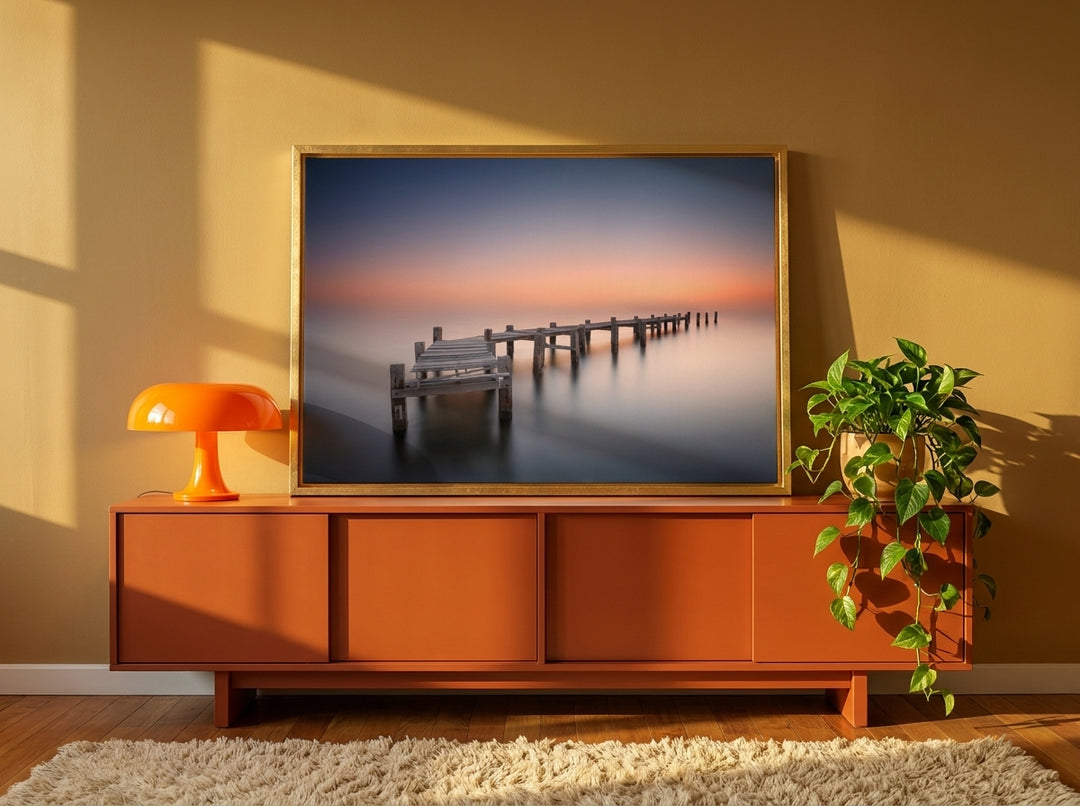 Canvas wall art with a gold leaf surround standing on a sideboard in a retro 70s bedroom