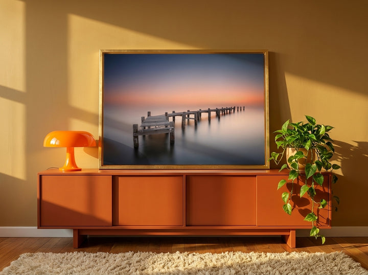 Canvas wall art with a gold leaf surround standing on a sideboard in a retro 70s bedroom