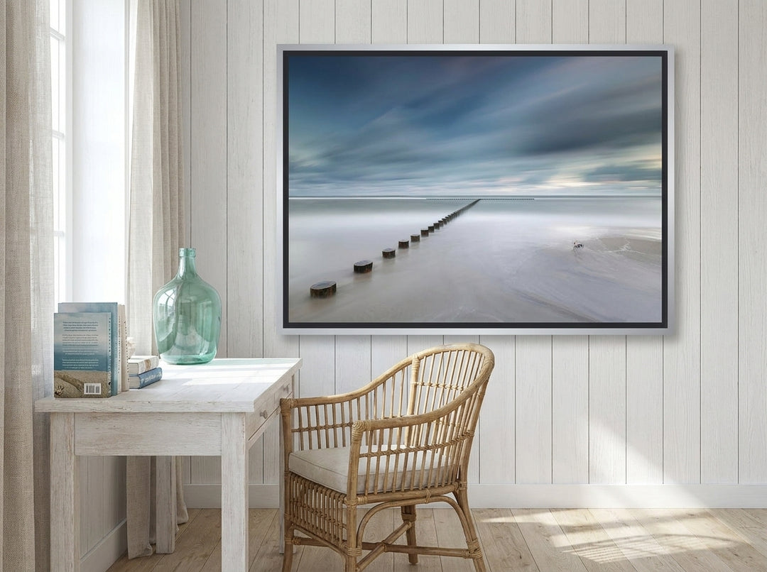 Canvas wall art with a silver leaf surround styled on the wall in a coastal home office