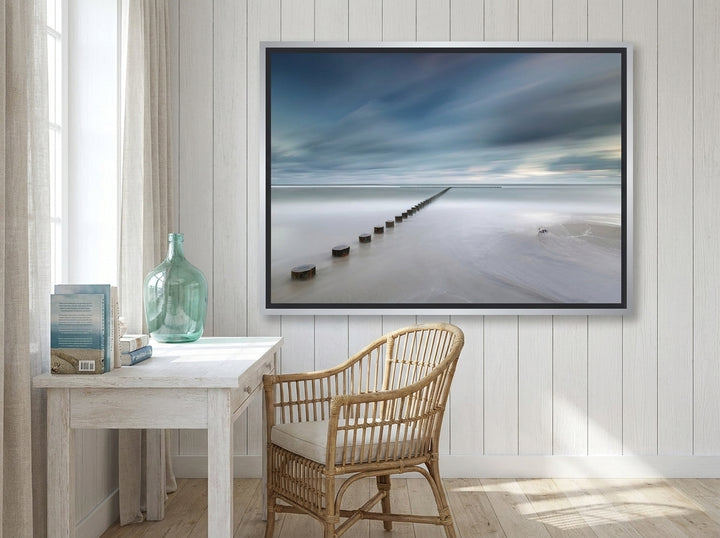 Canvas wall art with a silver leaf surround styled on the wall in a coastal home office