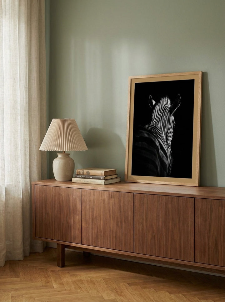 Modern wall art print standing on a sideboard in a mid-century bedroom
