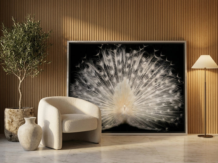 Oversized statement canvas wall art with a silver leaf surround leaning against the wall in a luxe living room