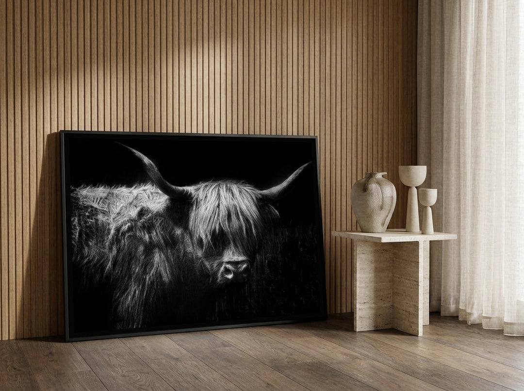 Oversized statement canvas wall art with a black surround leaning against the wall in a luxe living room