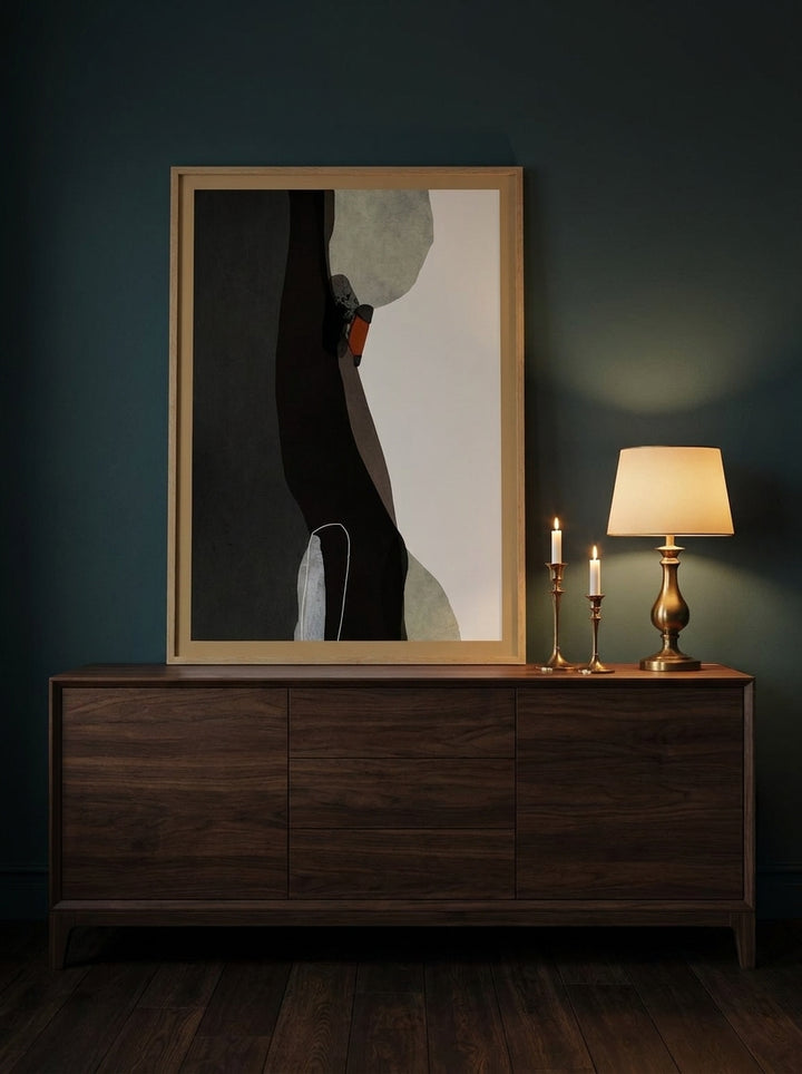 Modern wall art print standing on a sideboard in a moody bedroom