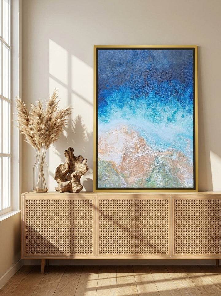 Canvas wall art with a gold leaf surround standing on a sideboard in a coastal living room