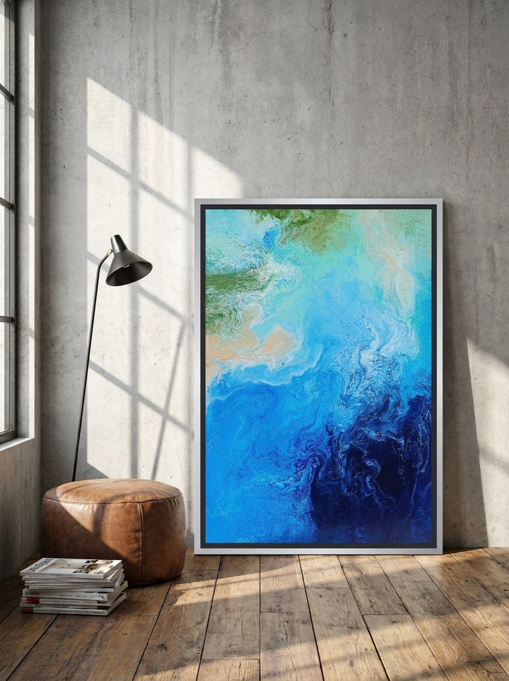 Canvas wall art with a silver leaf surround leaning against the wall in an industrial loft home office