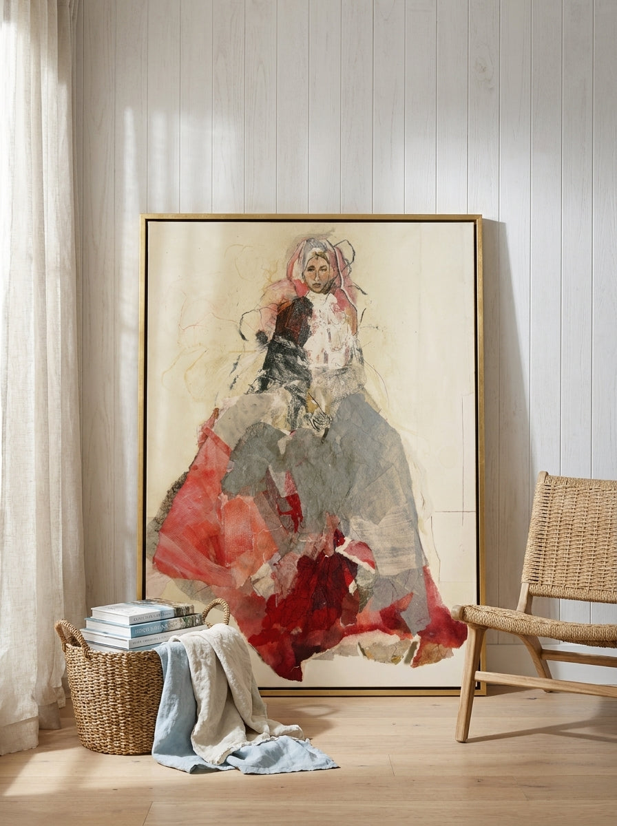Oversized statement canvas wall art with a gold leaf surround leaning against the wall in a coastal living room