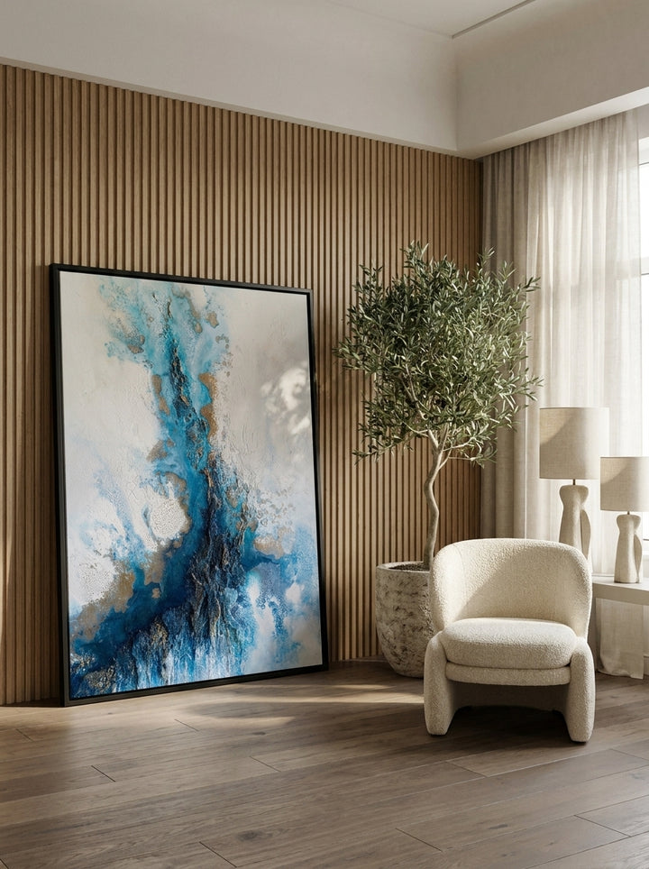 Oversized statement canvas wall art with a black surround leaning against the wall in a luxe living room