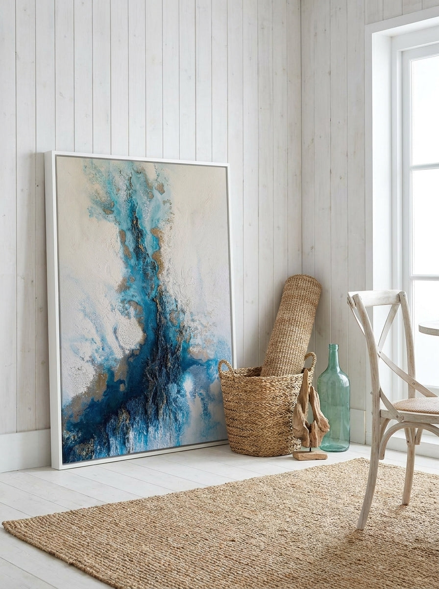 Canvas wall art with a white surround leaning against the wall in a coastal dining room