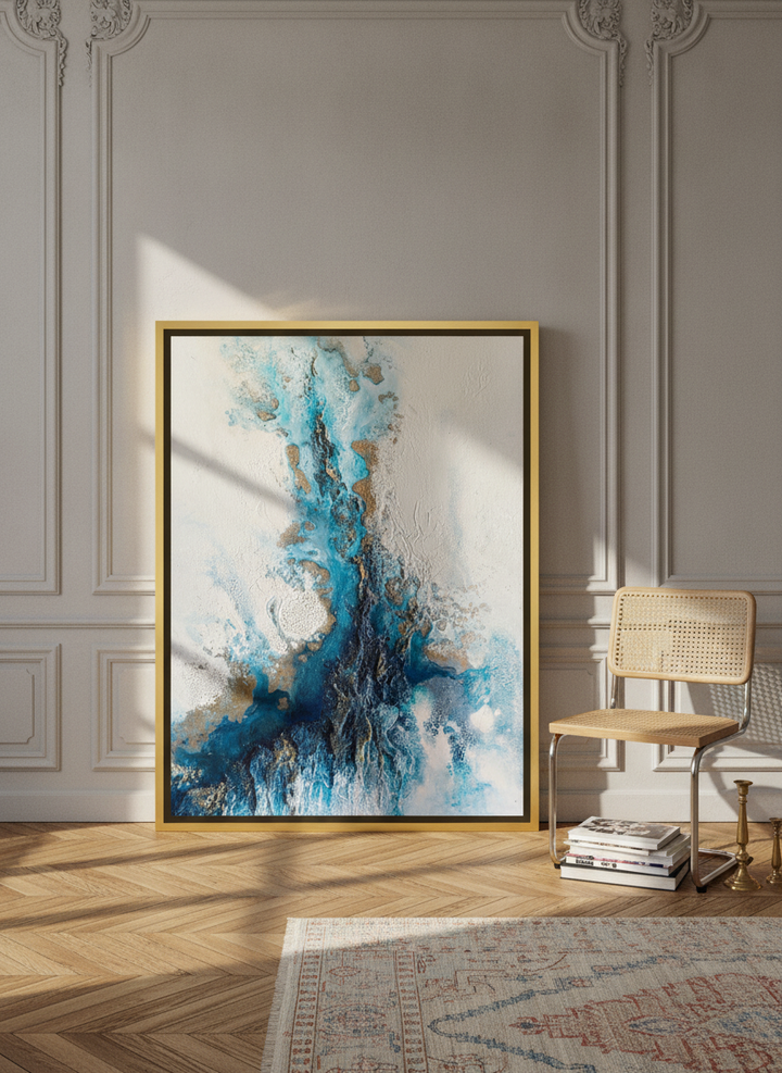 Oversized statement canvas wall art with a gold leaf surround leaning against the wall in a Parisian living room