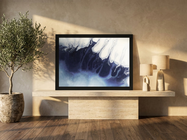 Modern wall art print standing on a console in a luxe bedroom