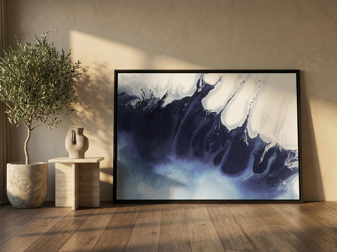 Oversized statement canvas wall art with a black surround leaning against the wall in a luxe bedroom