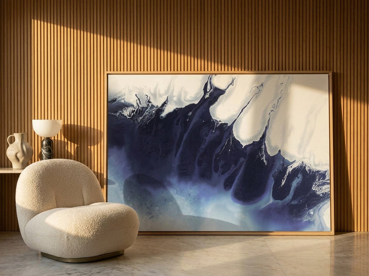 Oversized statement modern wall art print leaning against the wall in a luxe living room