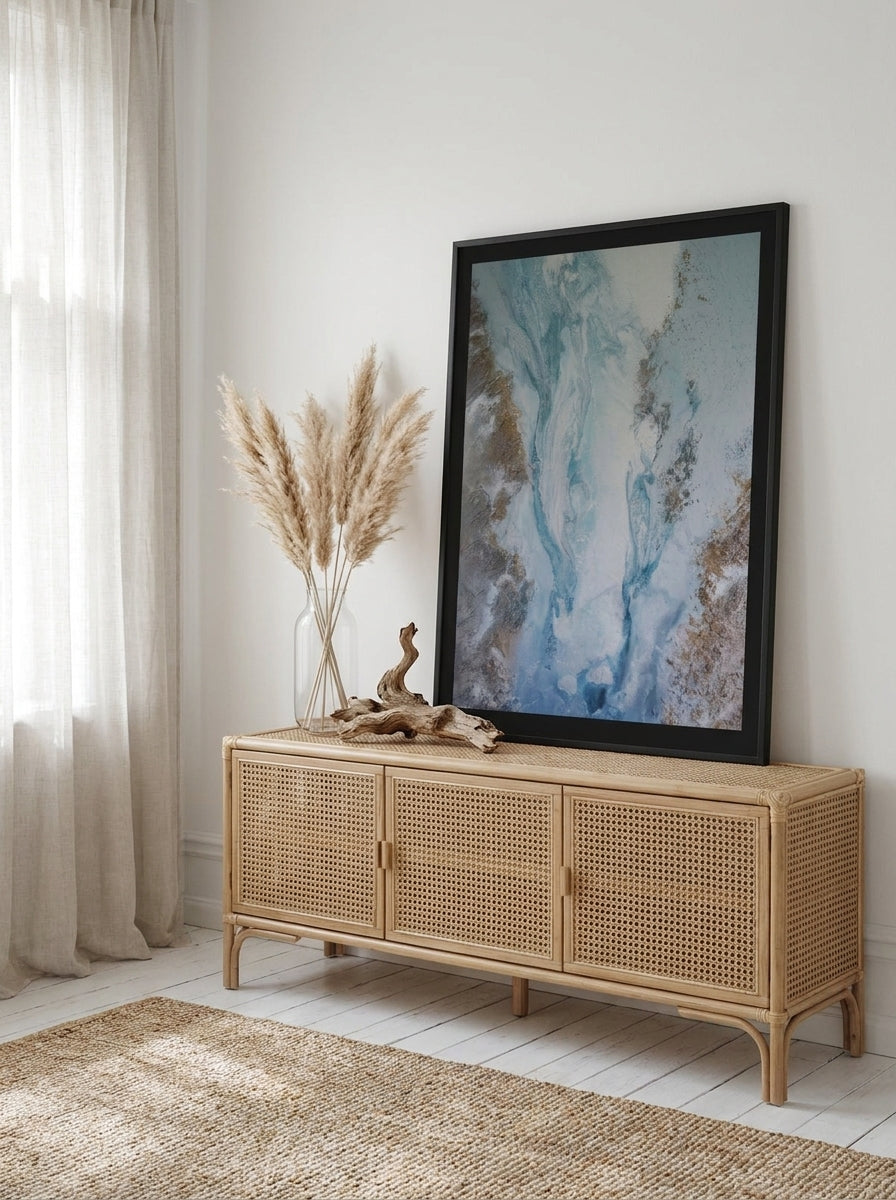 Modern wall art print standing on a sideboard in a coastal bedroom