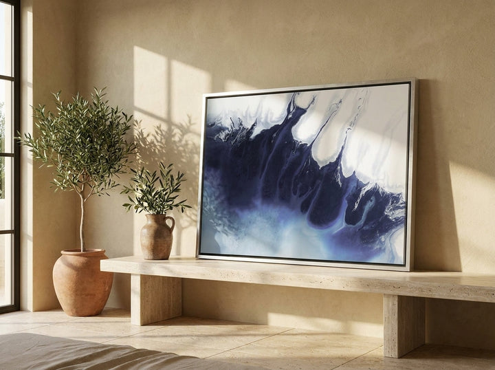 Canvas wall art with a silver leaf surround standing on a console in a Mediterranean bedroom