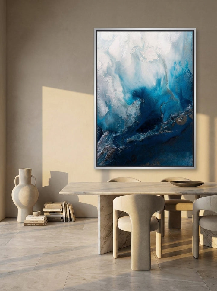 Oversized statement canvas wall art with a silver leaf surround styled on the wall in a luxe dining room