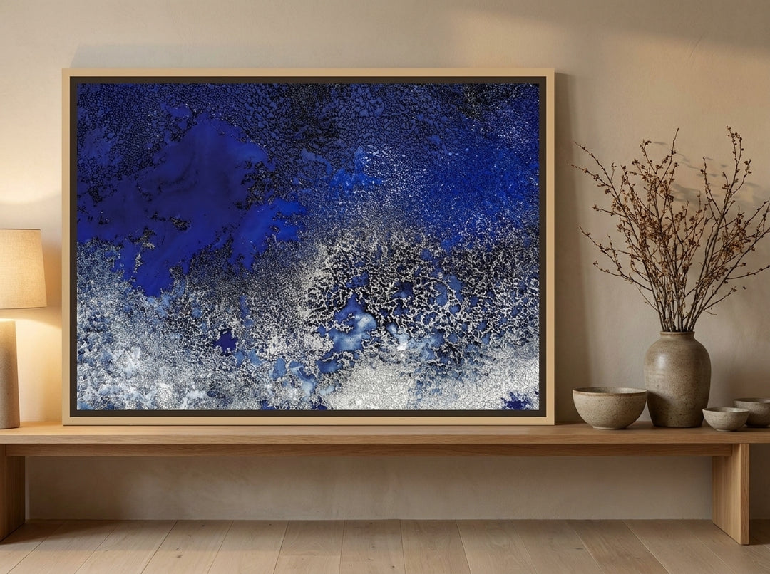 Canvas wall art with a natural timber surround standing on a bench in a warm Japandi bedroom