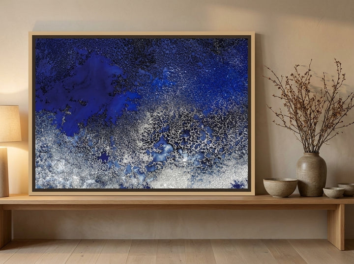 Canvas wall art with a natural timber surround standing on a bench in a warm Japandi bedroom
