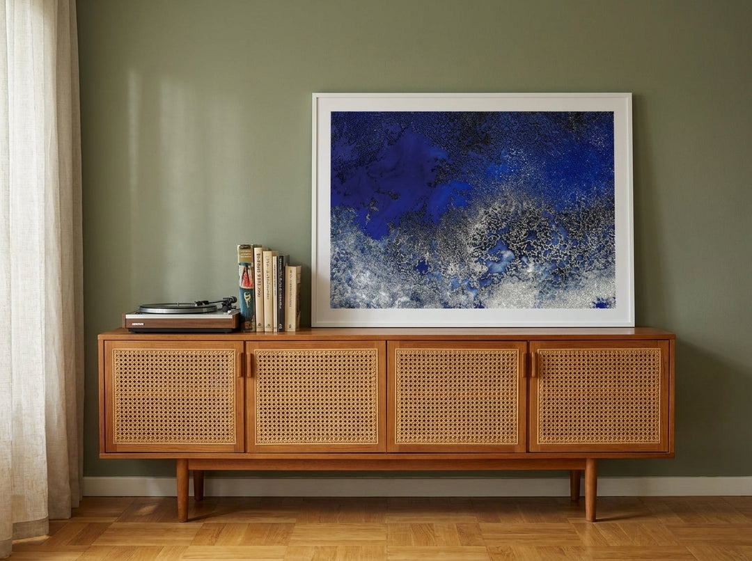 Modern wall art print standing on a sideboard in a mid-century bedroom