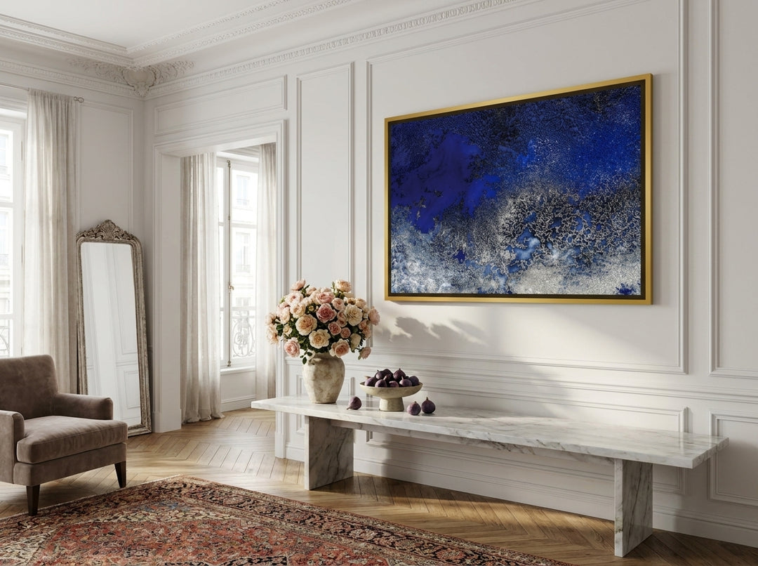 Oversized statement canvas wall art with a gold leaf surround styled on the wall in a Parisian living room