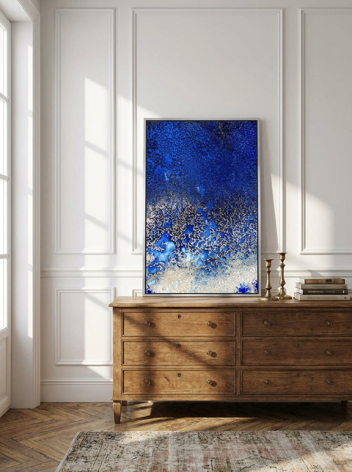 Canvas wall art with a silver leaf surround standing on a sideboard in a Parisian home office