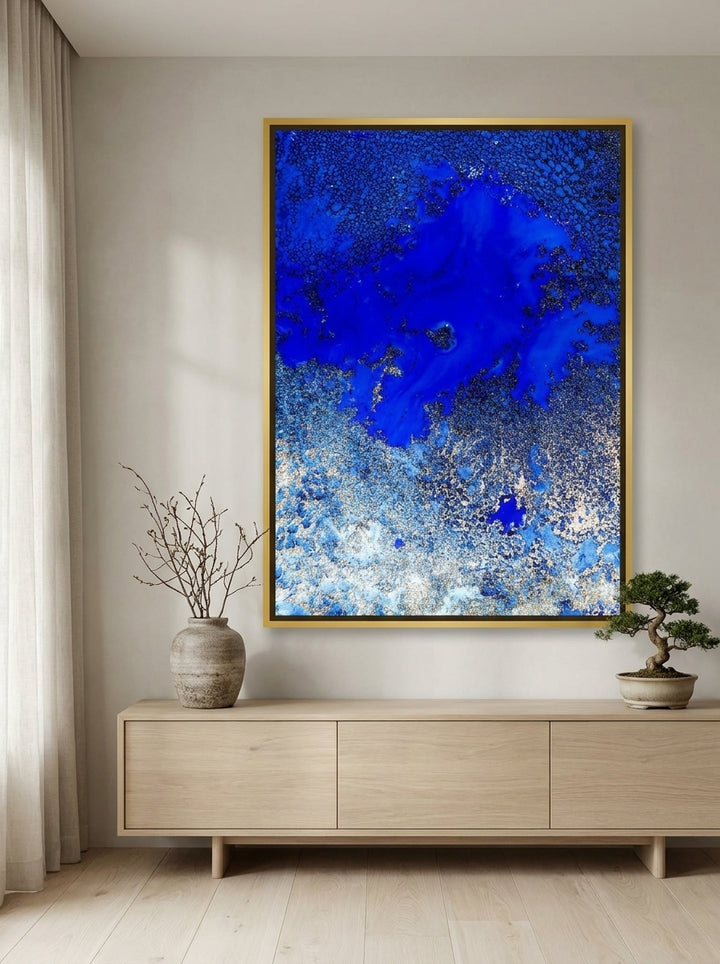 Oversized statement canvas wall art with a gold leaf surround styled on the wall in a warm Japandi living room