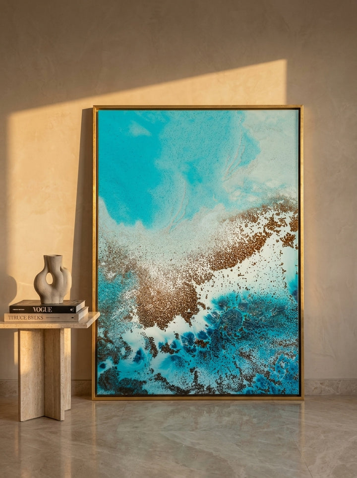 Oversized statement canvas wall art with a gold leaf surround leaning against the wall in a luxe dining room