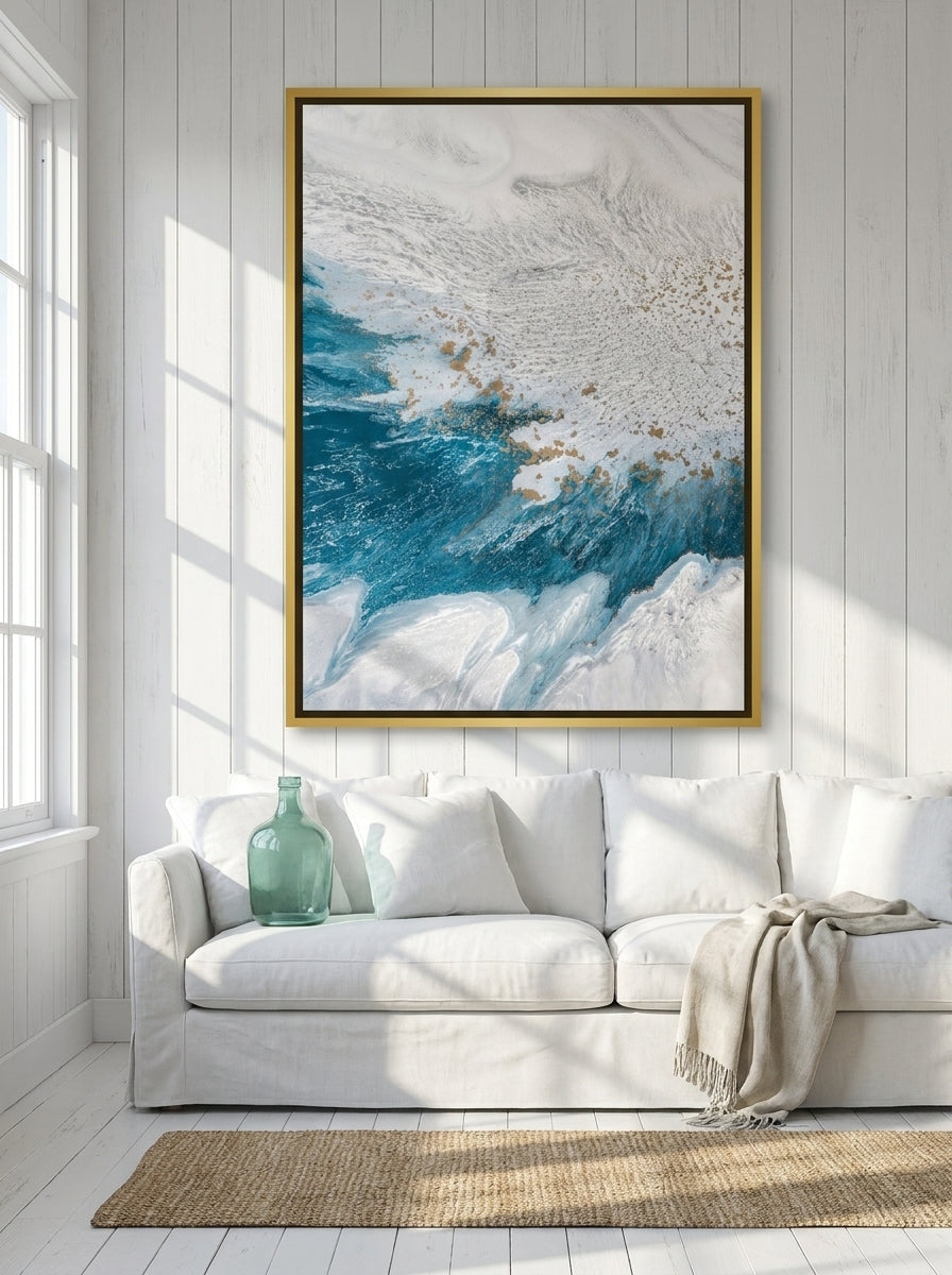 Oversized statement canvas wall art with a gold leaf surround styled on the wall in a coastal living room
