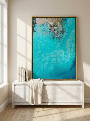 Canvas wall art with a gold leaf surround standing on a console in a coastal living room