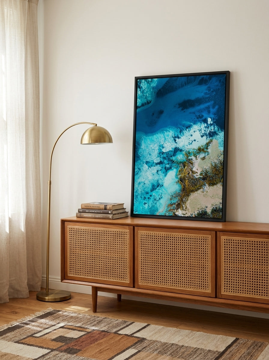 Canvas wall art with a black surround standing on a sideboard in a mid-century bedroom