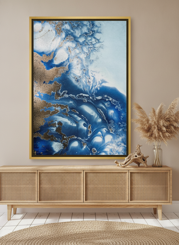 Canvas wall art with a gold leaf surround standing on a sideboard in a coastal bathroom