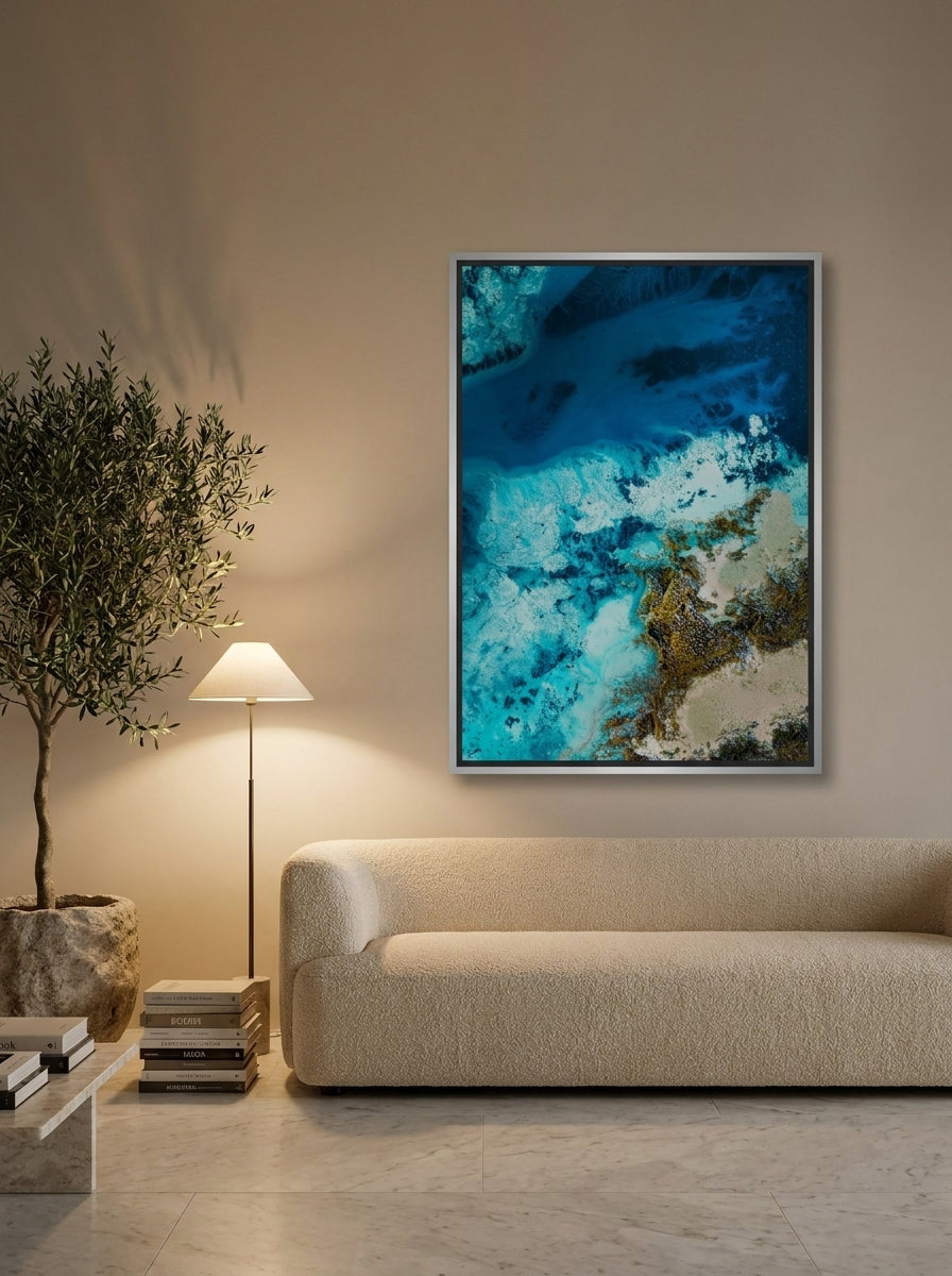 Oversized statement canvas wall art with a silver leaf surround styled on the wall in a luxe living room