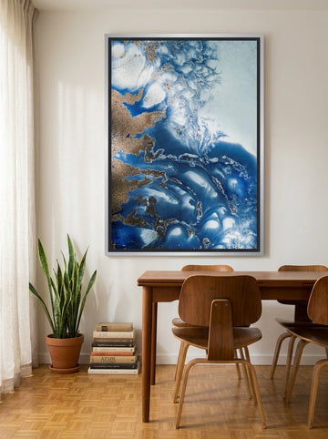 Oversized statement canvas wall art with a silver leaf surround styled on the wall in a mid-century dining room