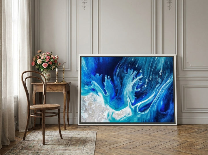 Canvas wall art with a white surround leaning against the wall in a Parisian bathroom