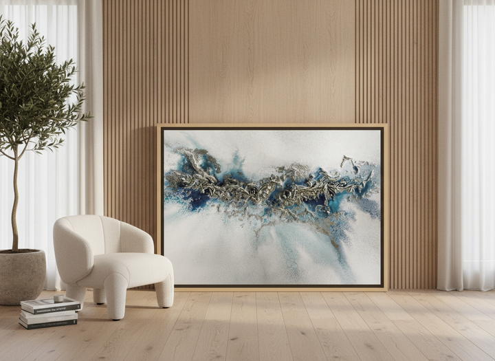 Oversized statement canvas wall art with a natural timber surround leaning against the wall in a luxe living room